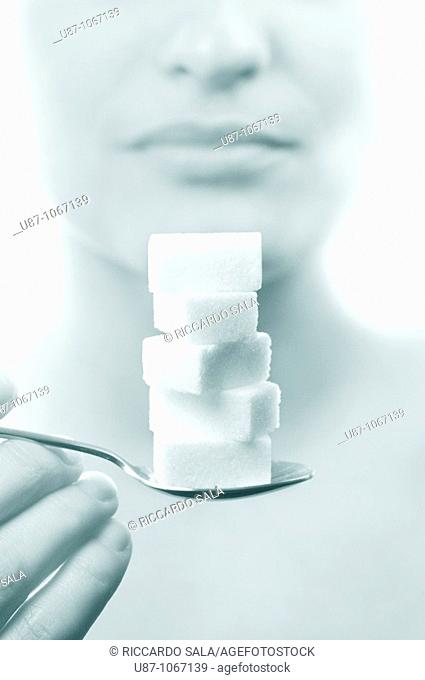 Woman holding spoon of sugar cube