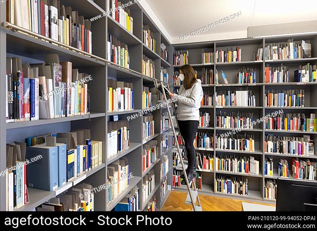 15 January 2021, Thuringia, Erfurt: Student assistant Juliane Podlaha stands in the academic library ""Éva Fahidi-Pusztai"" in the Topf & Sons Place of...