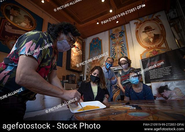 18 September 2021, Argentina, Buenos Aires: Argentine artist Jorge Muscia (l) shows guests in his studio the art of ""Filiteado""