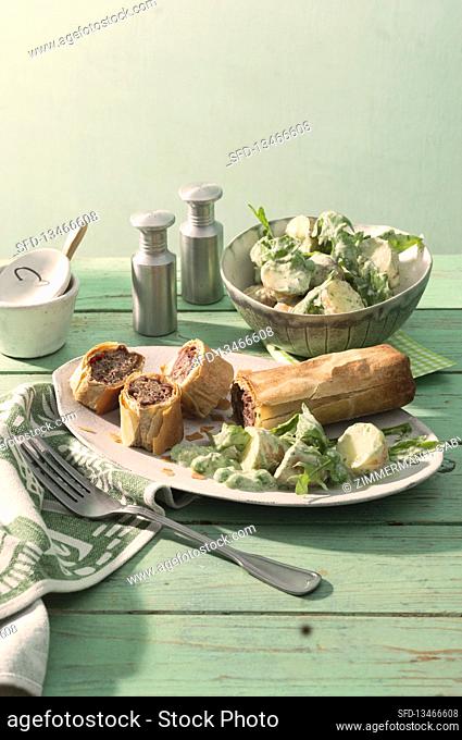 Vegetarian strudels with a pea filling and served with potato salad