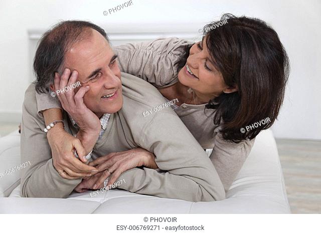 Middle-aged couple laying on bed
