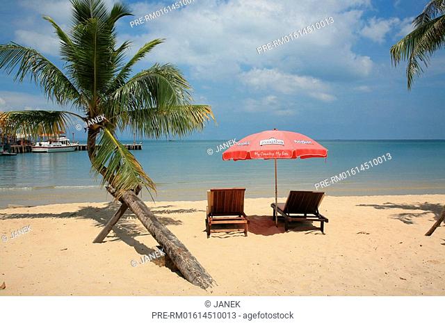 Sunchairs under palm trees at Victory beach in Sihanouk Ville, Cambodia, Asia