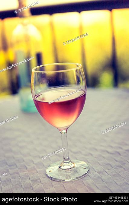 Glass of rose wine outdoors on the balcony. Evening scenery, Italy