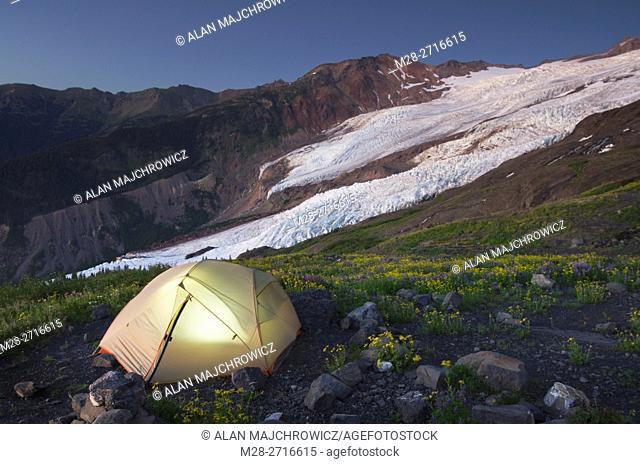 Tent illuminated at dusk on climbers camp on slopes of Heliotrope Ridge, Mount Baker Wilderness North cascades Washington