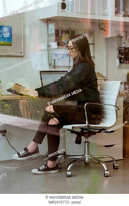 Female executive reading newspaper at desk