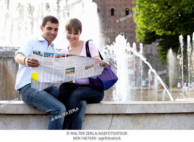 Young couple in front of the Castello Sforzesco, Milan, Italy