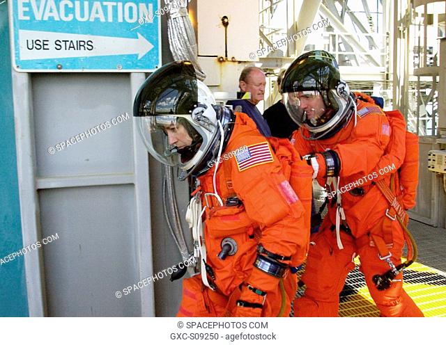 03/19/2002 - As part of emergency egress training, STS-110 Mission Specialists Ellen Ochoa and Rex J. Walheim make their way to the slidewire basket on the...