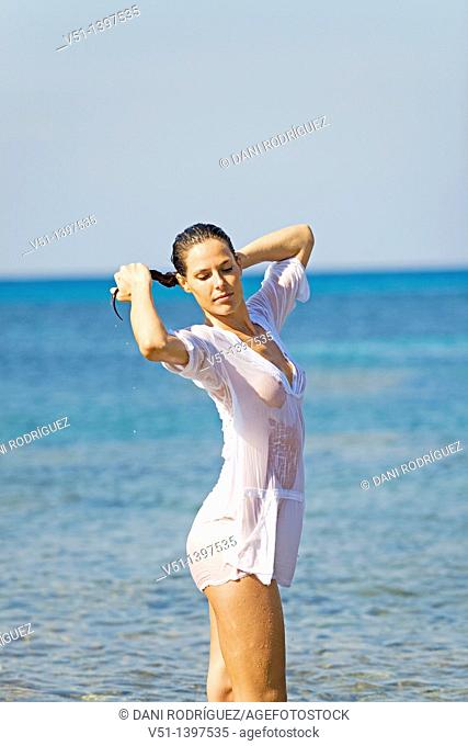 Sensual brunette woman wet with a shirt in the water