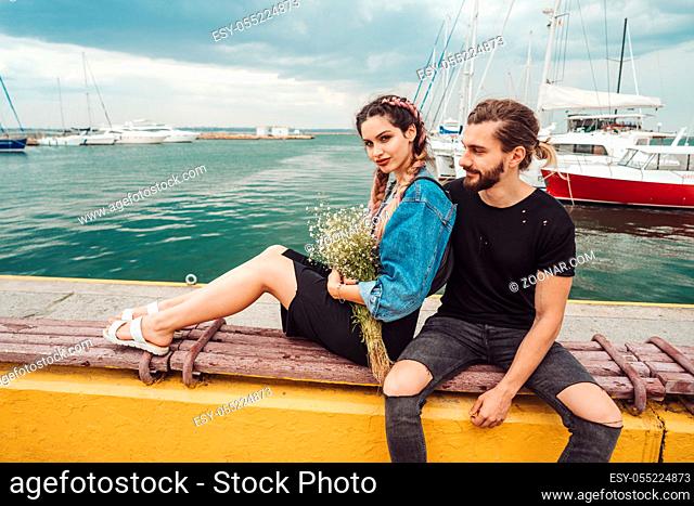 Guy and girl on pier posing on camera