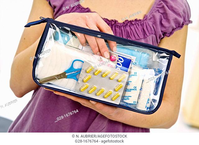 Close up of a Young woman in mauve holding a transparent first aid kit