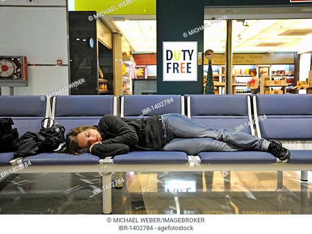 Passenger, exhausted, sleeping in front of the duty-free shop in the waiting area of the boarding gate, Fuerteventura Airport, Canary Islands, Spain, Europe