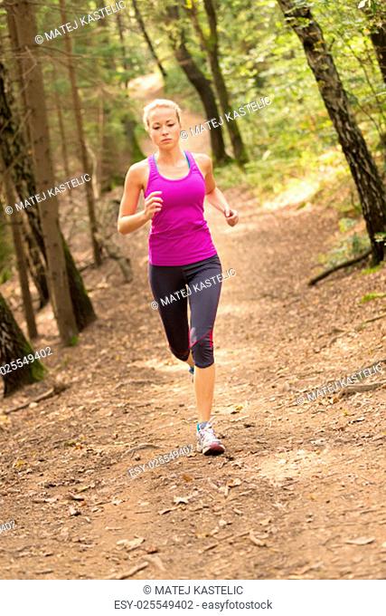 Pretty young girl runner in the forest. Running woman. Female Runner Jogging during Outdoor Workout in a Nature. Beautiful fit Girl