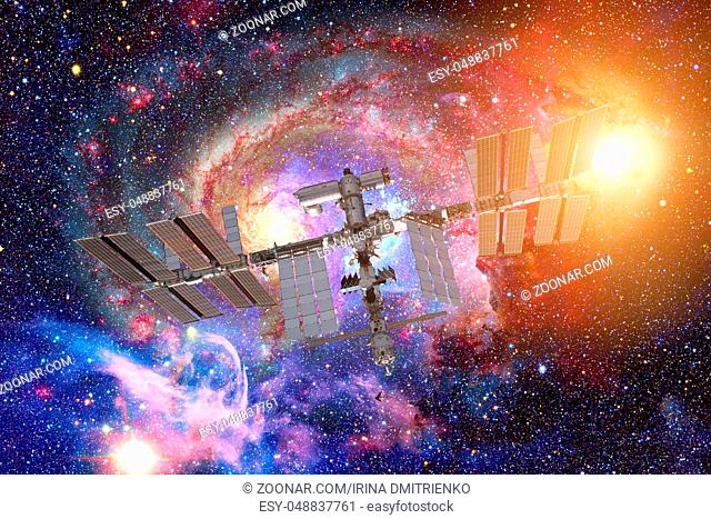 International Space Station over spiral galaxy Earth. Elements of this image furnished by NASA