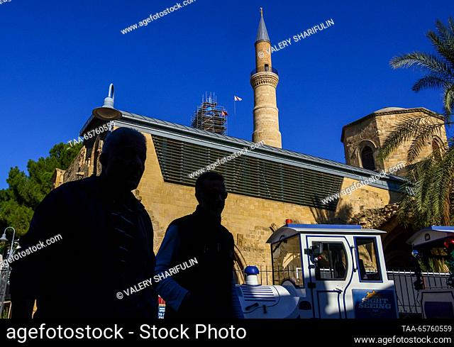 CYPRUS, NICOSIA - DECEMBER 14, 2023: Men walk past the Selimiye Mosque, a Christian cathedral until the 16th century. The Turkish Republic of Northern Cyprus is...