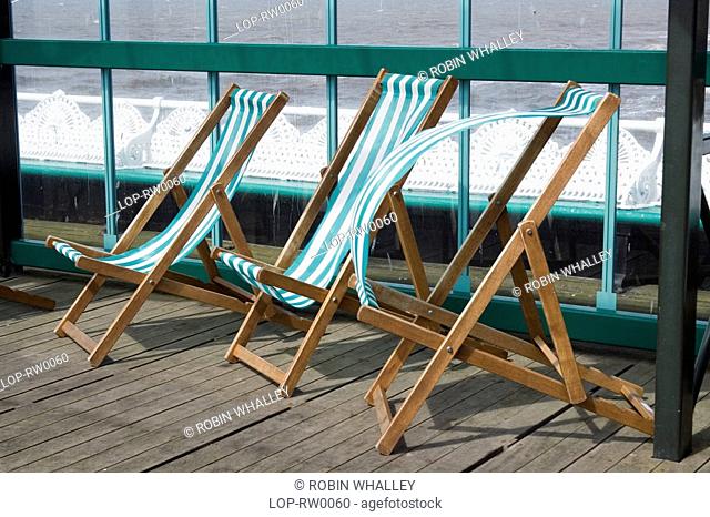England, Lancashire, Blackpool, Empty striped deck chairs on the North Pier at Blackpool