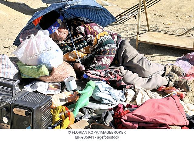 Elderly man sleeping under an umbrella, salesman at the market of El Alto, La Paz, Bolivia, South America