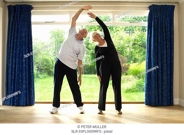 Couple stretching together indoors