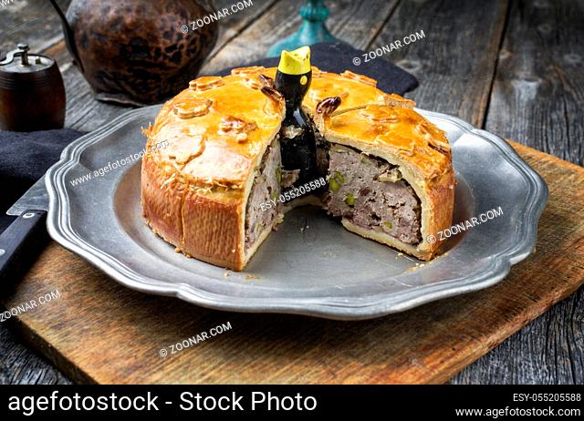 Traditional French Pate en croute with goose meat and liver as closeup on a pewter plate