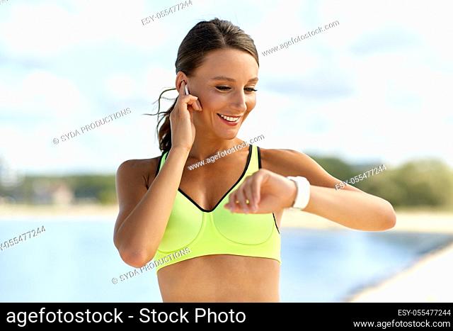 woman with earphones and smart watch doing sports