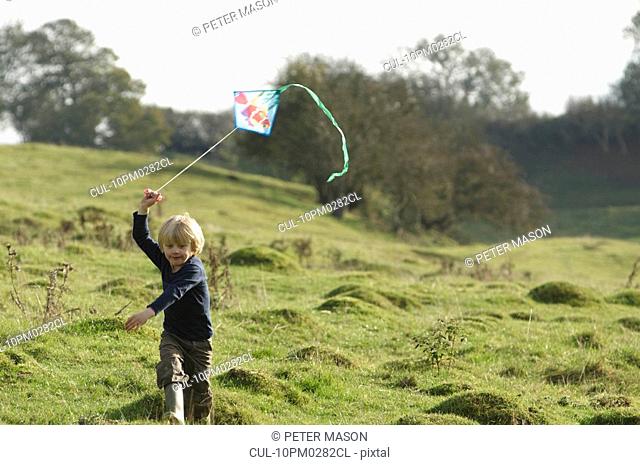 Young boy running with kite