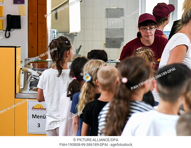 07 August 2019, Berlin: Before lunch, pupils stand in the cafeteria in the primary school on the Wuhlheide in the queue in front of the food counter