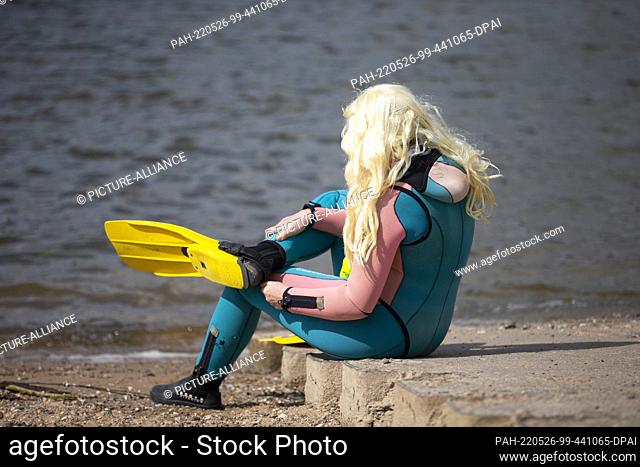 26 May 2022, North Rhine-Westphalia, Cologne: A member of the German Underwater Club Cologne (DUC Köln) e.V. costumed with a wig takes part in the annual Rhine...