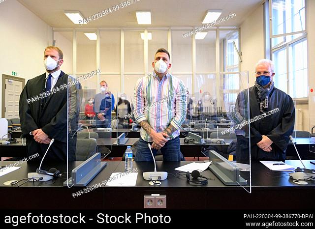 04 March 2022, Hamburg: Rapper Gzuz (m, real name Kristoffer Jonas Klauß) stands between his lawyers Christopher Posch (l) and Ulf Dreckmann (r) in a courtroom...