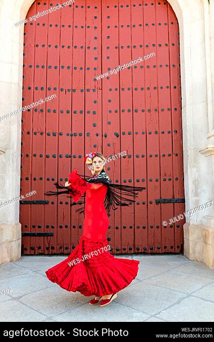 Female flamenco dancer dancing on footpath