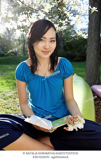 young woman reading book outdoor