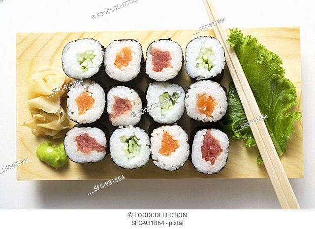 Maki sushi with fish and cucumber on sushi board