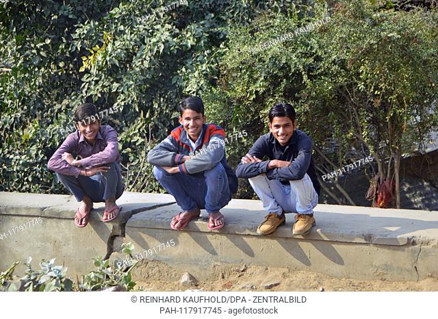 Young men sit laughsd in northern India in the state of Rajasthan on a wall, taken on 01.02.2019 | usage worldwide. - /Rajasthan/Indien