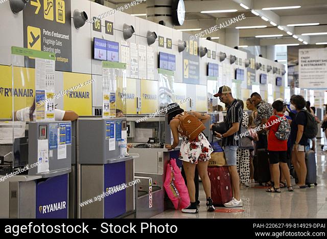 24 June 2022, Spain, Palma: People stand at the check-in counters of Ryanair at Palma de Mallorca Airport. Photo: Clara Margais/dpa