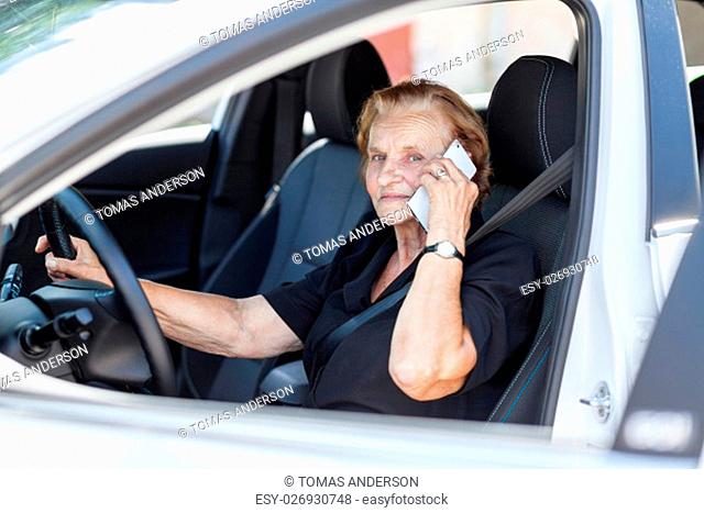 Elderly woman behind the steering wheel of a car