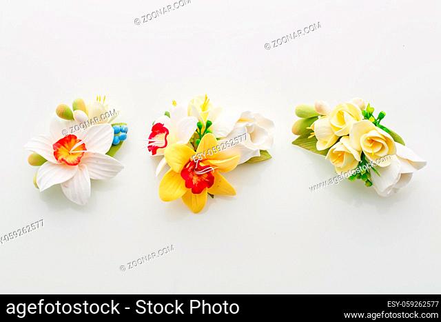 Beautiful handmade art clay spring flower bouquets. Bridal accessory. Boutonniere. Over white background