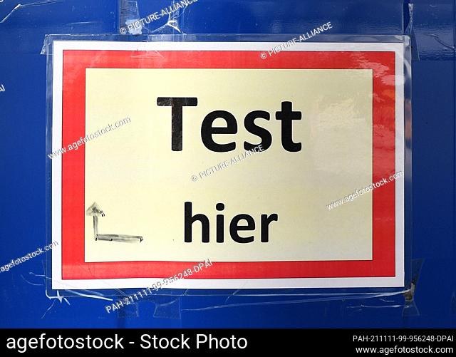11 November 2021, Bavaria, Oberammergau: ""Test here"" can be read on a Corona test container. Photo: Angelika Warmuth/dpa