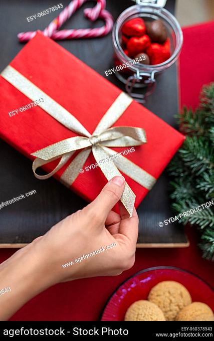 hand with christmas gift, treats and decorations
