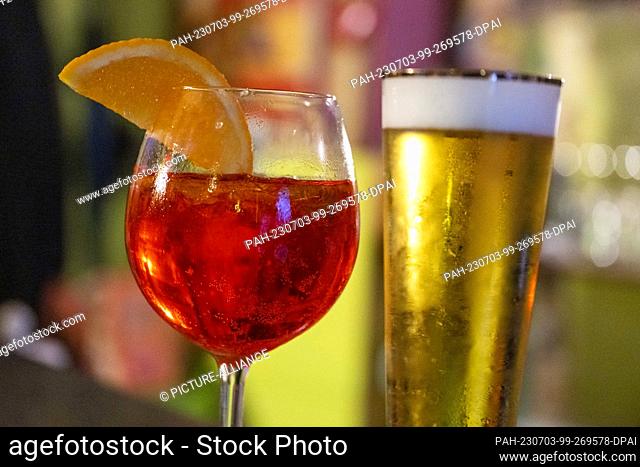 PRODUCTION - 01 July 2023, Berlin: In a bar, a glass of Aperol Spritz and a glass of non-alcoholic beer are on the counter
