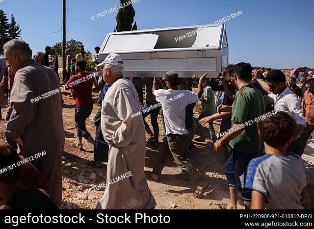 08 September 2022, Syria, Hafsarjah: Syrians carry the coffin of a man who was killed as a result of a Russian air raid on the village of Hafsarjah in the...