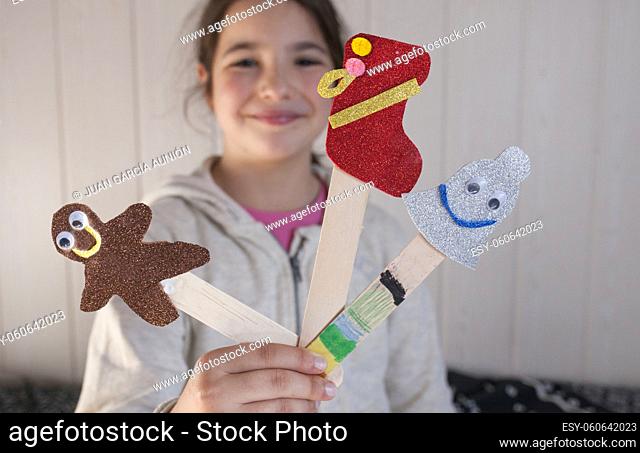 Child girl showing her Christmas page markers. Christmas holidays activities for children concept