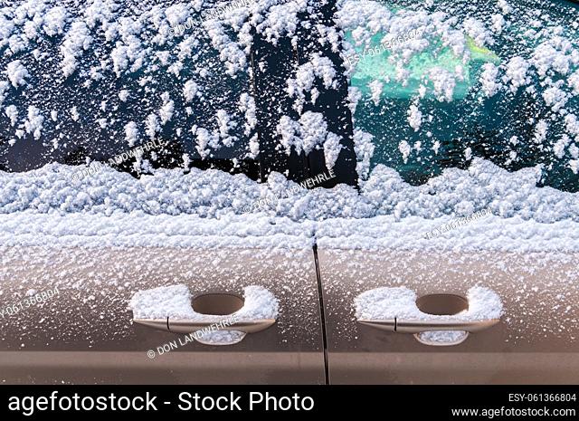 Snow covered car door handles and windows
