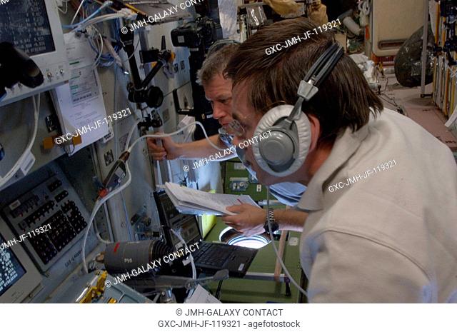Russian cosmonauts Yuri Malenchenko (foreground) and Oleg Novitskiy, both Expedition 33 flight engineers, monitor data at the manual TORU docking system...