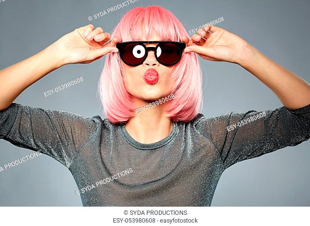 woman in pink wig and sunglasses sending air kiss