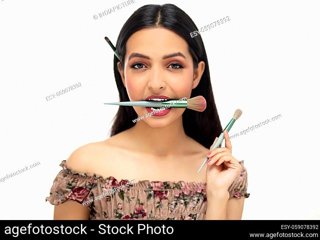 Portrait of beautiful fashion model applying professional makeup