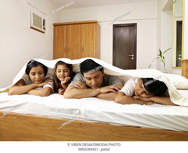 Parents with children under bed sheet sleeping on bed in bedroom MR702R, MR702S, MR702T, MR702U
