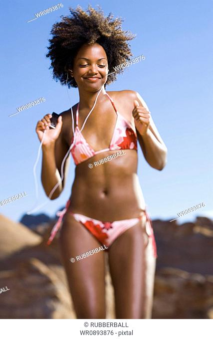 Low angle view of a young woman dancing with listening to an MP3 Player