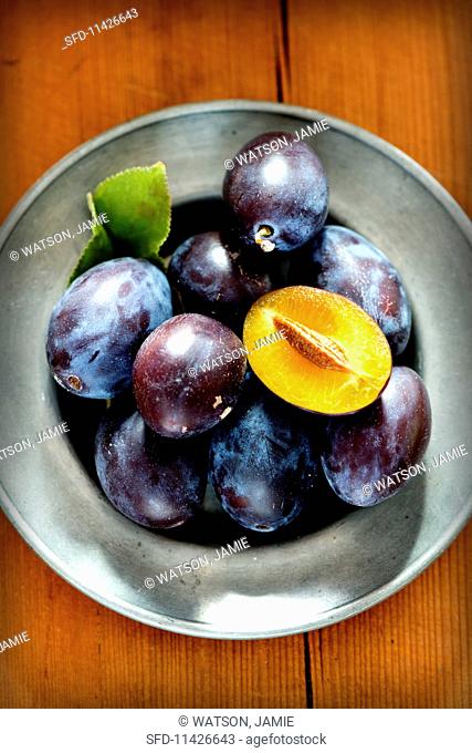 Fresh plums on a pewter plate