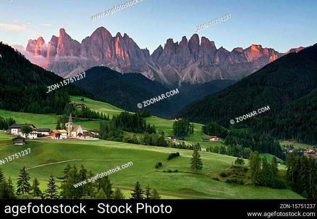 Village of Santa Magdalena and church on the Italian mountains Dolomites Alps at sunrise
