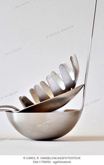 Silver stainless steel kitchen utensils: spoon, ladle and pasta fork