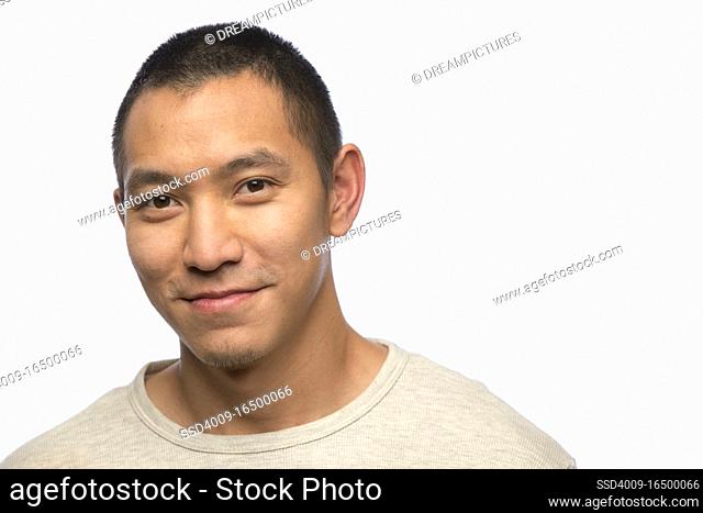 Portrait of young man of Asian descent on white background