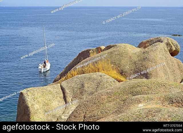 Rocks and sea, sailboat on the Pink Granite Coast, Brittany, France (Côte de Granit Rose)